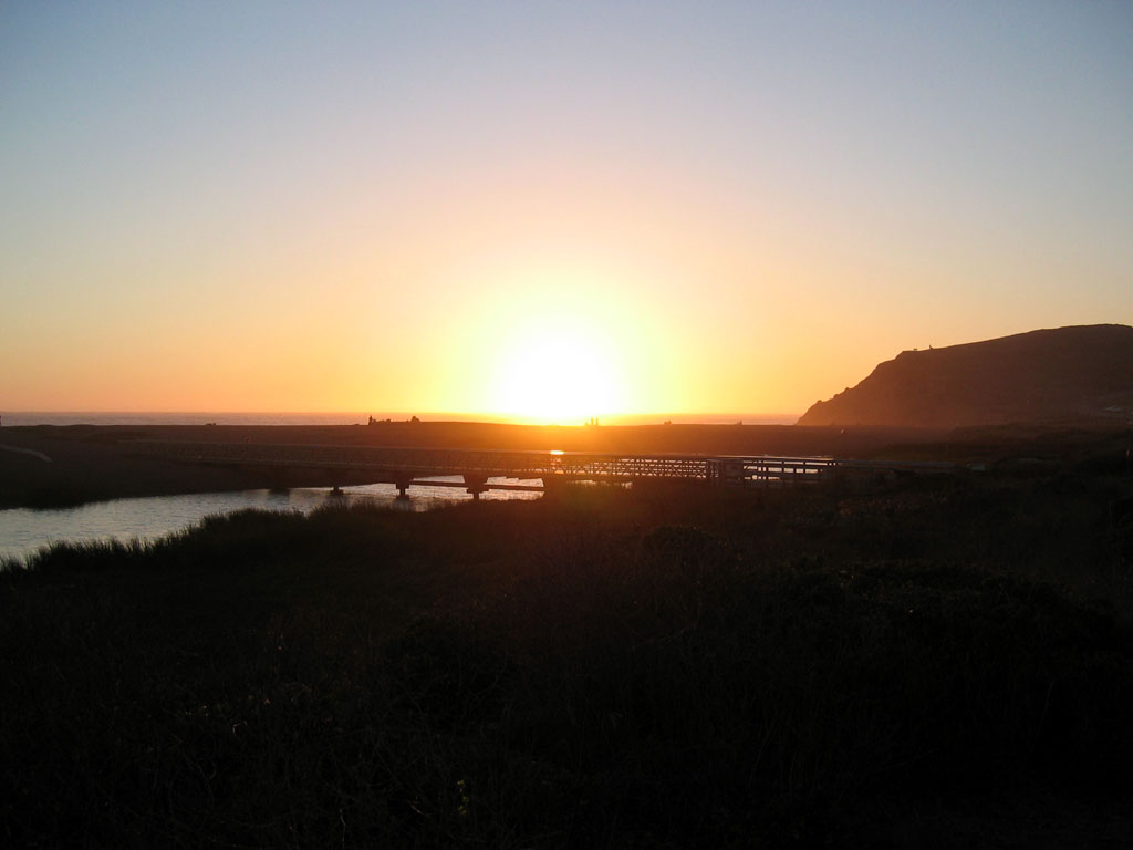 Rodeo Beach - Sun approaching the water behind the footbridge acroos Rodeo Lagoon