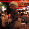 A young boy happily skips past one of the outdoor food stands