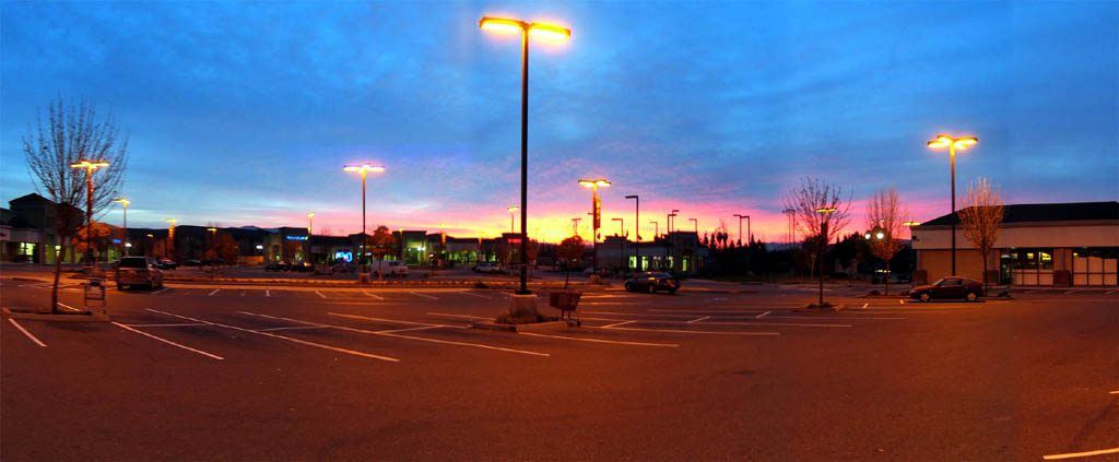 San Jose - Panorama of dawn helping low pressure sodium lamps light up a parking lot