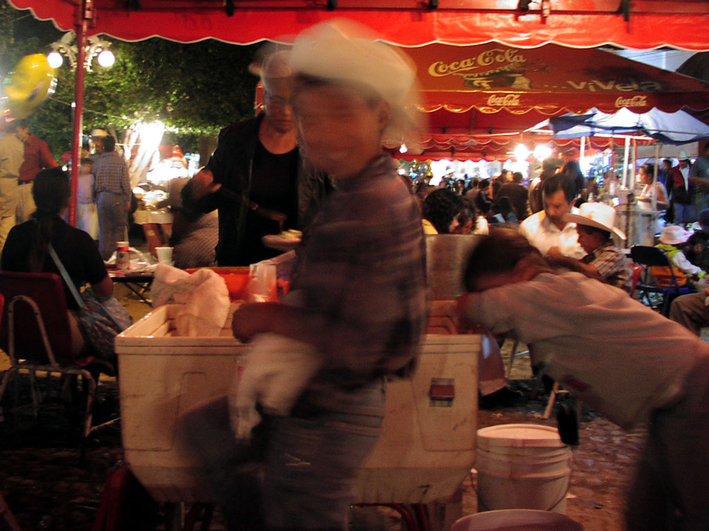 A young boy happily skips past one of the outdoor food stands